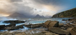 Waves crashing on shoreline with moody dramatic sky at Elgol on the Isle of Skye, Scotland, UK.