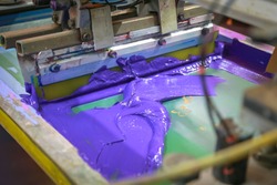Purple screen on fabric using screen machine In the printing factory.