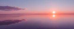 Landscape beautiful golden sunset red sky solt lake saline Elton Baskunchak. The sun sets behind the horizon