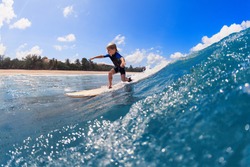Happy surf boy - young surfer learn to ride on surfboard with fun on sea waves. Active family lifestyle, kids outdoor water sport lessons, swimming activity in surfing camp. Summer vacation with child