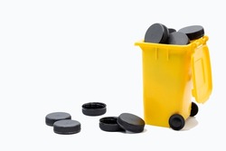 Yellow bucket for plastic recycling, caps and lids. plastic bottle stopper.recycling plastic bottle caps.colored caps.black plastic caps.