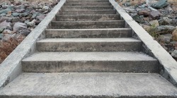 Concrete stairs with rocks beside.