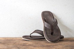 Men sandals footware brown on wood grunge table desk with copy space.