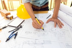 Team of construction engineer working hard project blueprint to build large commercial buildings and golf course houses.