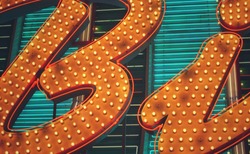 Close up of bright yellow and blue neon light letters on a sign.