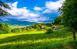 Mountain village on the green hills. Village in mountains. Rural summer landscape. Countryside summer landscape in mountains