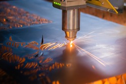 Laser cutting machine working with sheet metal with sparks at factory, plant. Metalworking, industrial, equipment, technology, machining, manufacturing concept
