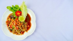 Papaya Salad, Papaya Salad with Crab and Pickled Fish Spicy Thai food put on a white plate, top view