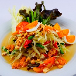 Thai-Thai style salted egg papaya salad topped with papaya noodles, tomatoes, long beans and sprinkled with peanuts. Dried shrimp with a side of lettuce in a beautiful view