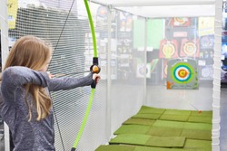 girl shoots a bow in a children's shooting range
