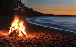 Glowing Bonfire on the Beach at Sunset