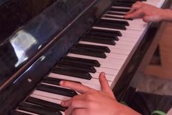 Child plays old piano his hands with fingers.