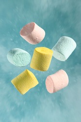 colorful marshmallows flying on blue background
