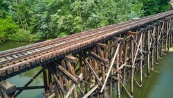 Railroad old wood bridge over river from aerial side