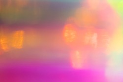 Blurred pink and yellow abstract lens flare background. Defocused glow effect. Illuminated bokeh