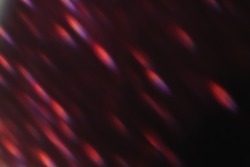 Lens flare overlay. Bokeh light. Flash leak. Blur optical rays. Defocused neon red purple sparks glow on dark night abstract background.
