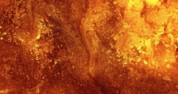 Glitter ink background. Paint mix. Volcanic eruption. Hot lava leak. Defocused orange golden color glow shiny fluid abstract texture.