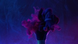 Paint water splash. Color smoke blast. Creative imagination. Neon pink blue dye mix in light bulb on dark mist gradient abstract art background.