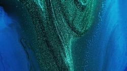 Glitter ink. Abstract background. Sparkling wave. Defocused shiny shimmering green blue color liquid paint blend grain texture with free space.