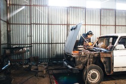 Mechanic repair and service car in garage