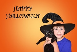 A child in a hat holds a black cat. Happy scary Halloween, baby