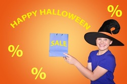 A child in a hat holds shopping bags. Happy scary Halloween, baby. The concept of sales