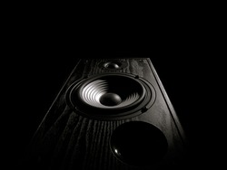 black and white toned image of an audio speaker isolated on a black background