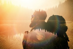 Portrait of stylish bearded man with glasses and tourism backpack.  Double exposure, view on  the beautiful mountain lake. Wide, sunset effect.