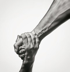 Concept of salvation. Black and white image of the hands of two people at the time of rescue (help).