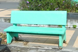 cement benches painted green and placed on each side of the park for visitors to sit and rest