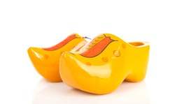 pair of traditional Dutch yellow wooden shoes over white background 