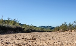 low angle of a gravel road with blue skies