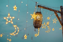Lighting decor elements at a party outdoors. Cozy lights lanterns and light garland background.