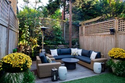 Patio. Garden. Urban, neutral, outdoor living space. Exterior photo. Outdoor living room with couch, comfy cushions, throw pillows, love seat, chairs and coffee table. Backyard with greenery, plants.