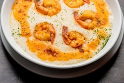 Shrimp and Grits. Grits and old bay seasoned jumbo shrimp topped with spices and micro greens. Classic American Diner Style Breakfast or Brunch menu item. Traditional low country southern staple. 