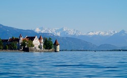 beautiful island of Lindau on lake Constance (lake Bodensee) with the snowy Swiss Alps in the background, Germany on fine sunny spring day                               