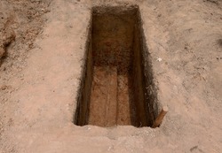 Excavation of the soil to the depth of the burial hole containing the body