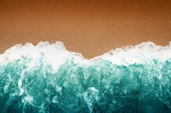 Top View, Wave of Turquoise ocean water on sandy beach, High angle view sea and sand background, Teal color and Dark Brown Wallpaper.