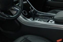 Interior Design of New Car. Automatic gearbox and media controller close up. Elements of a luxury premium sedan. Car air conditioning and climate control. The interior of a modern business class car