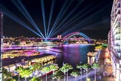Circular Quay and Sydney Harbour Bridge illuminated with colorful light, during the Vivid Sydney 2017 