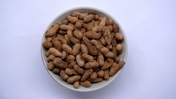 A bowl of roasted peanuts on isolated background