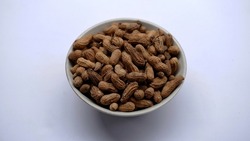 a bowl of roasted peanuts on a isolated background