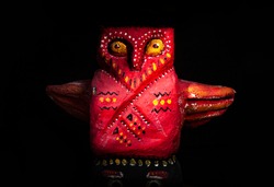 A statuette of a magical character, a protective totem of a pagan image and religion, on a dark background