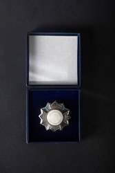 Medal, insignia, in an open box on black velvet, on a dark background