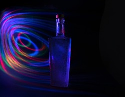 high-necked bottle illuminated by arched lines of light