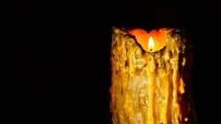 Old candle with drips of wax in the dark, selective focus, abstraction