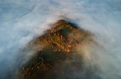 drone view at sunrise over beautiful landscape of mountain range with misty clouds in valley bottom. view from above on amazing hills at early morning.