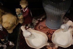 Photograph of bird objects in white, vase object in blue, angel object and puppy dog object