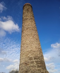 Old chimney at Troopers Hill in Bristol against a blue and cloudy sky