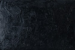 Irregular black plaster texture applied with a spatula on a wal